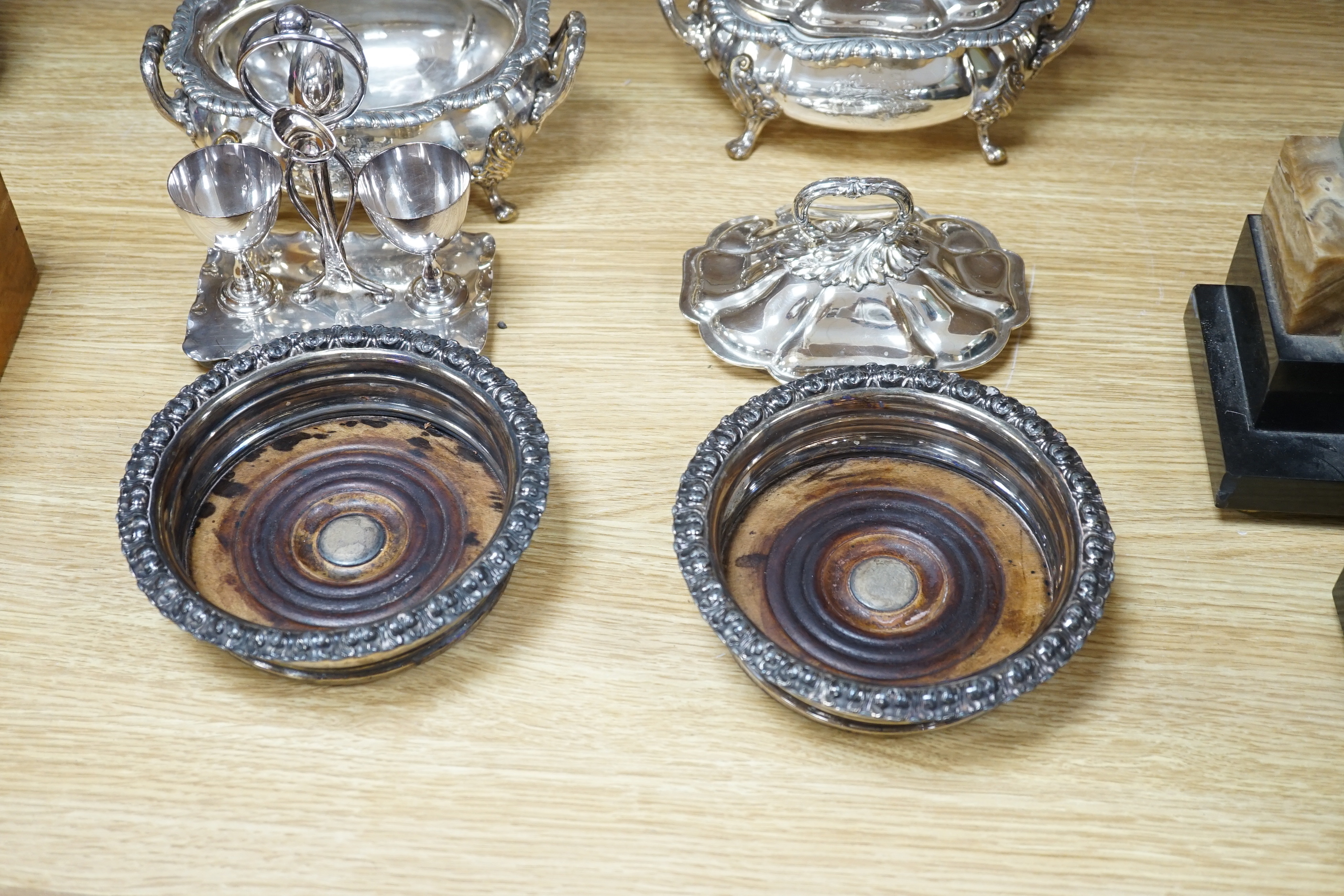 Silver plated items including two wine coasters, tureens and egg cup stand, largest 24cm high